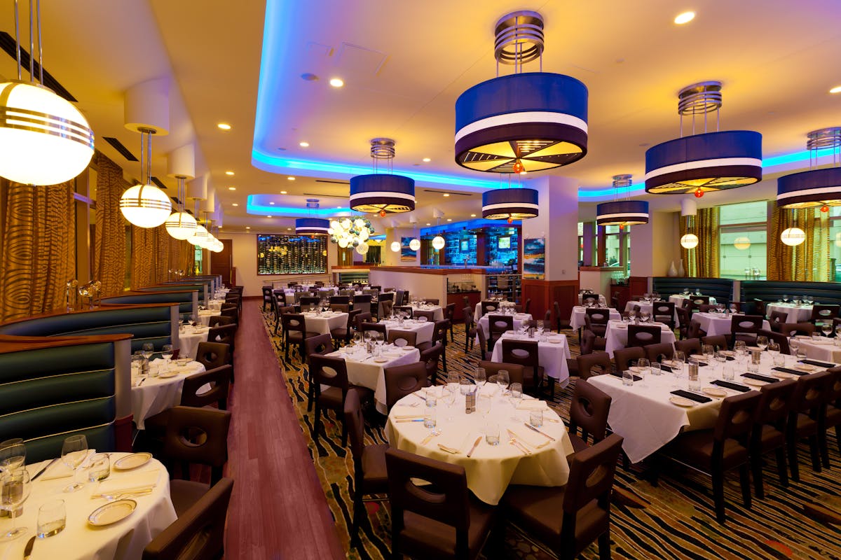 a room filled with dining tables, furniture and a large window