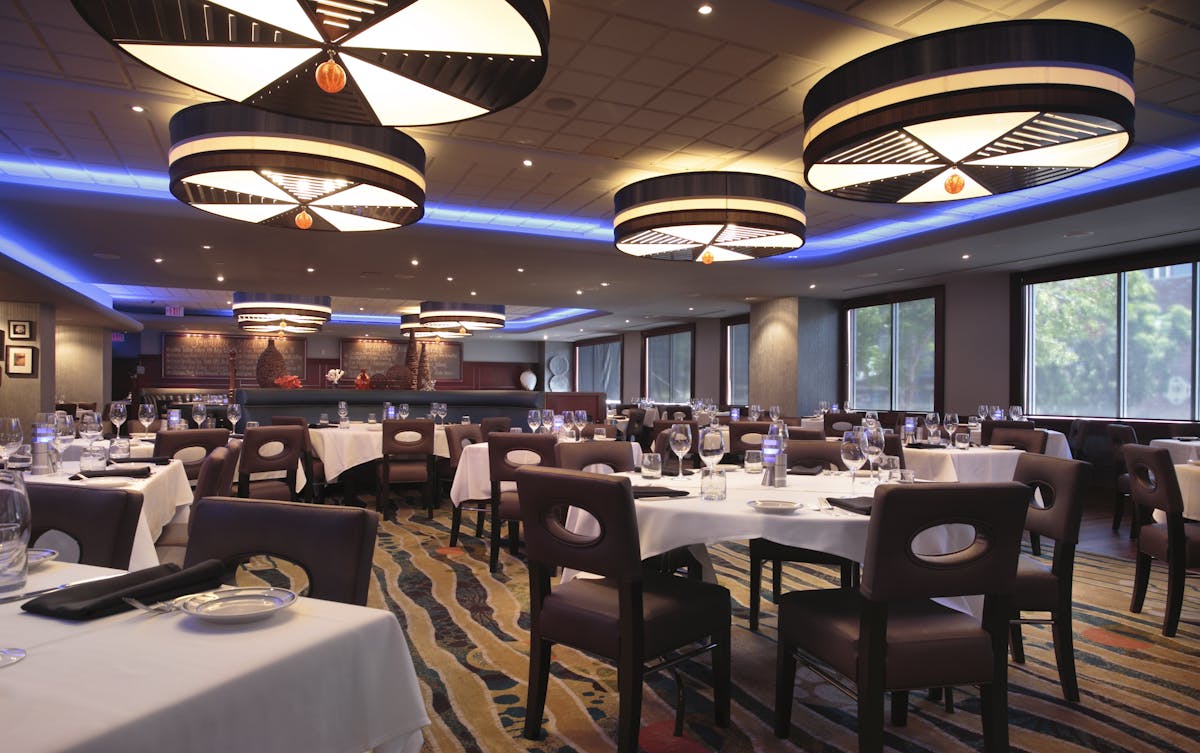 a room filled with dining tables, furniture and a large window
