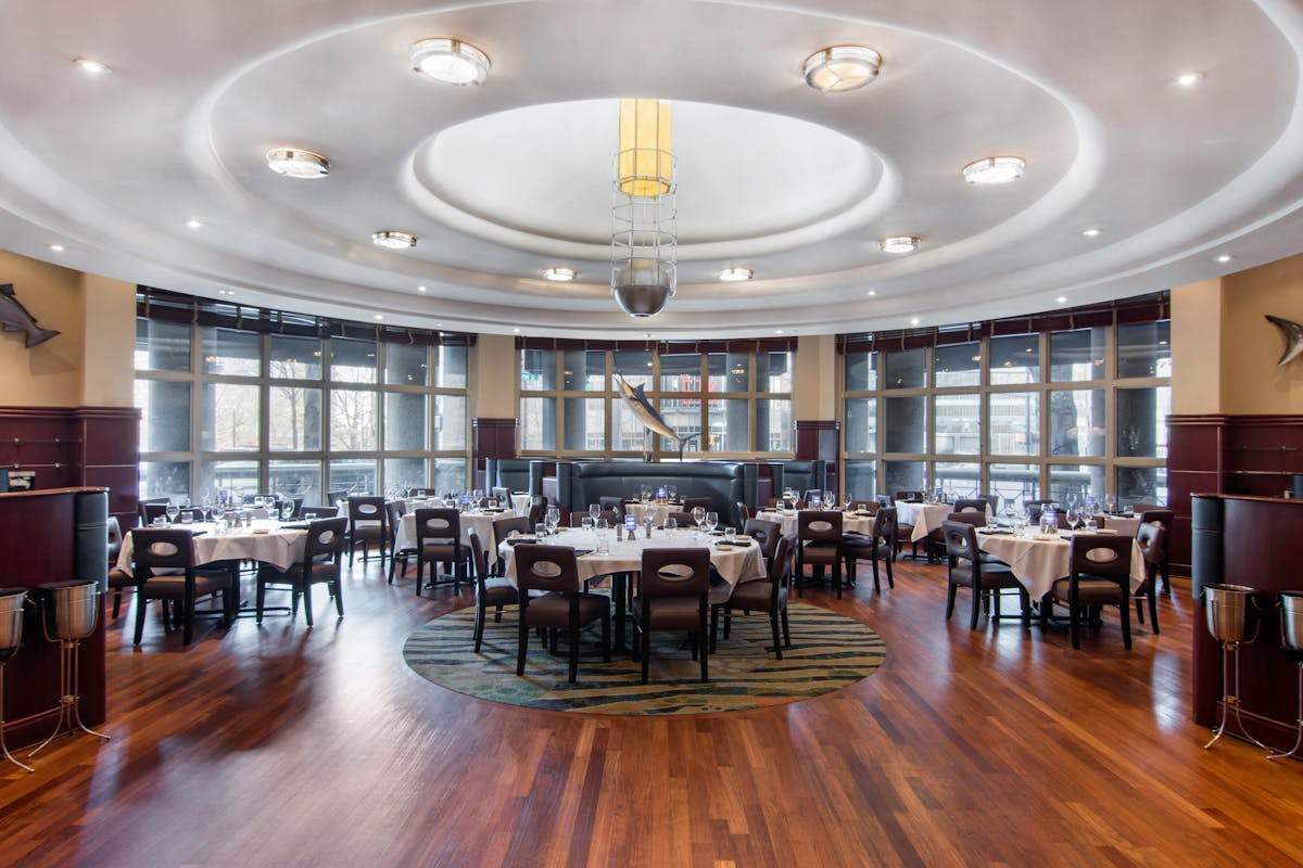 a room filled with dining tables, furniture and a large window