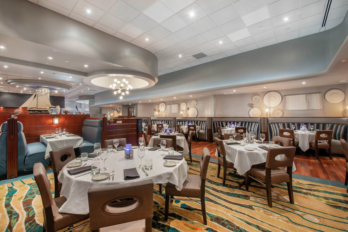 a room filled with dining tables, furniture and a large window