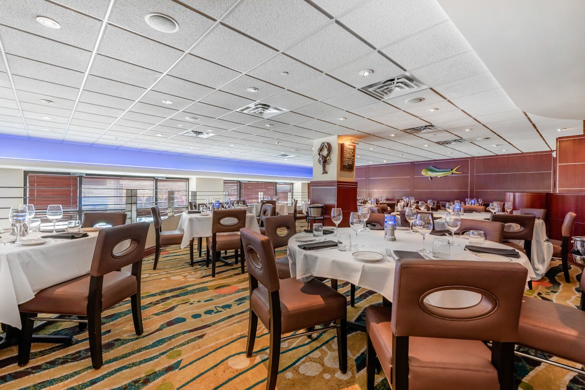 a room filled with dining tables, furniture and a large window