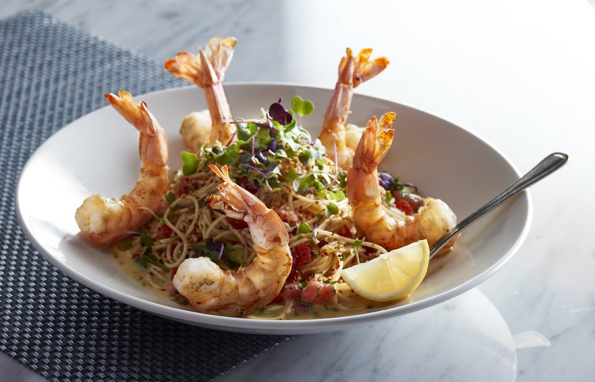 a bowl of shrimp with coleslaw and noodles