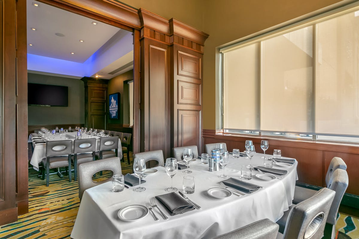 a room filled with dining tables, furniture and a large window