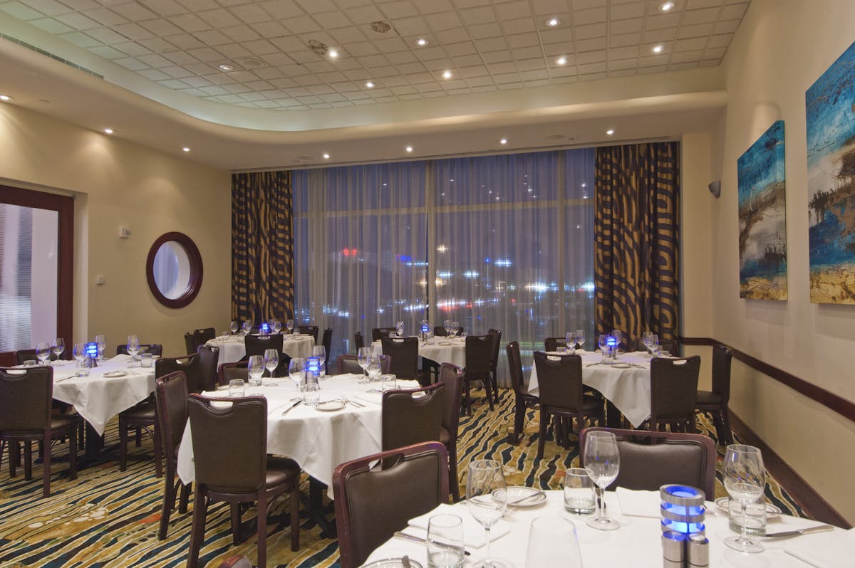 a room filled with dining tables, furniture and a large window