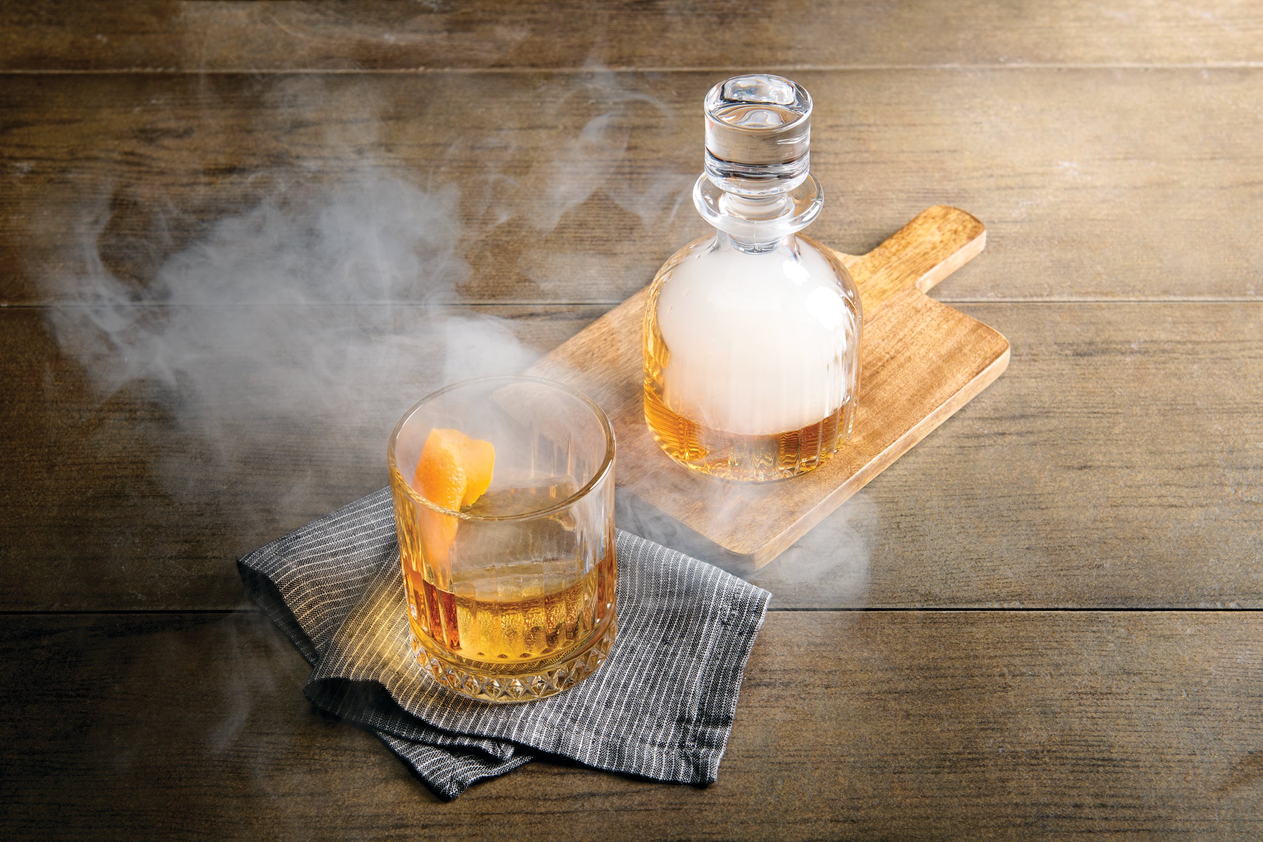 a glass of liquid and a bottle of smoke