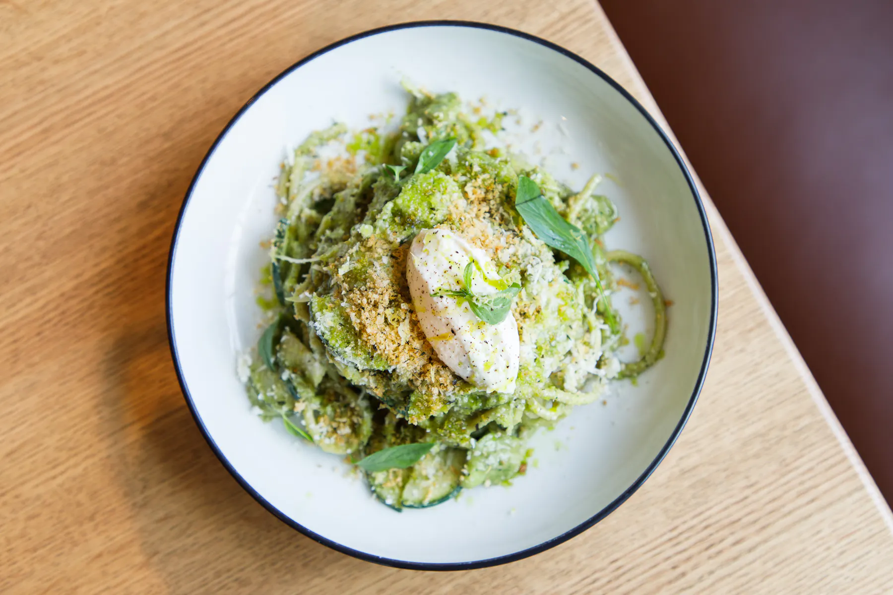 a plate of pasta with pesto and ricotta cheese