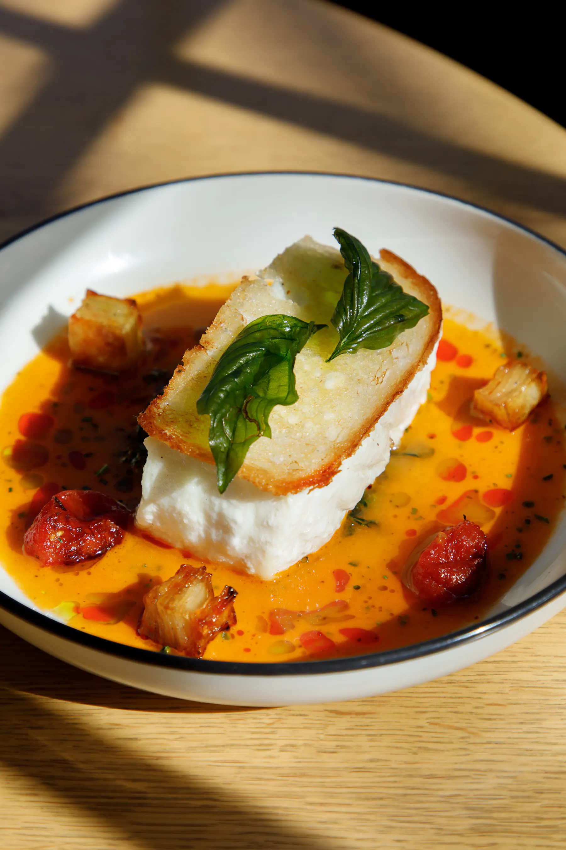 a plate of halibut with a tomato sauce