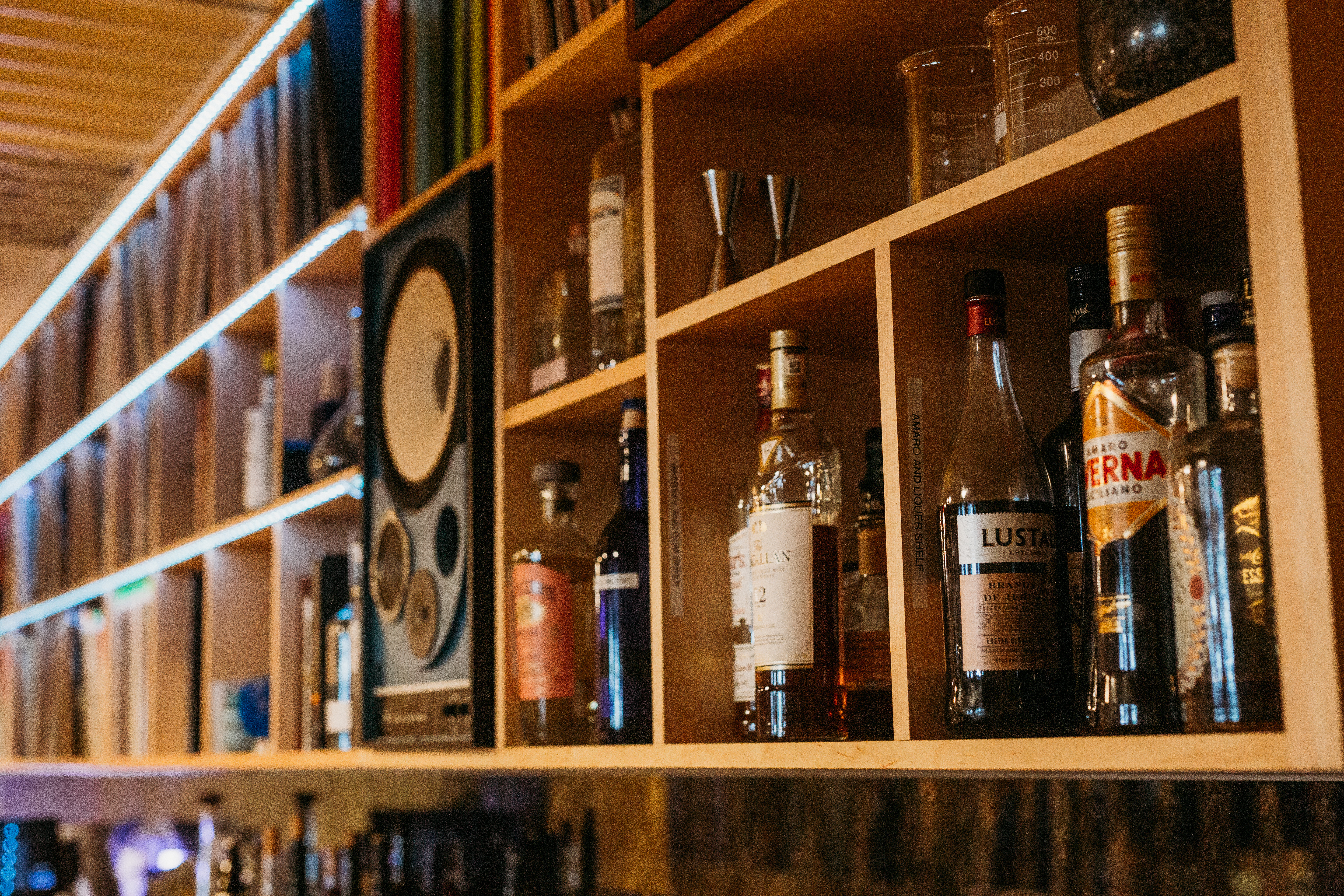 a bottle next to a book shelf filled with books