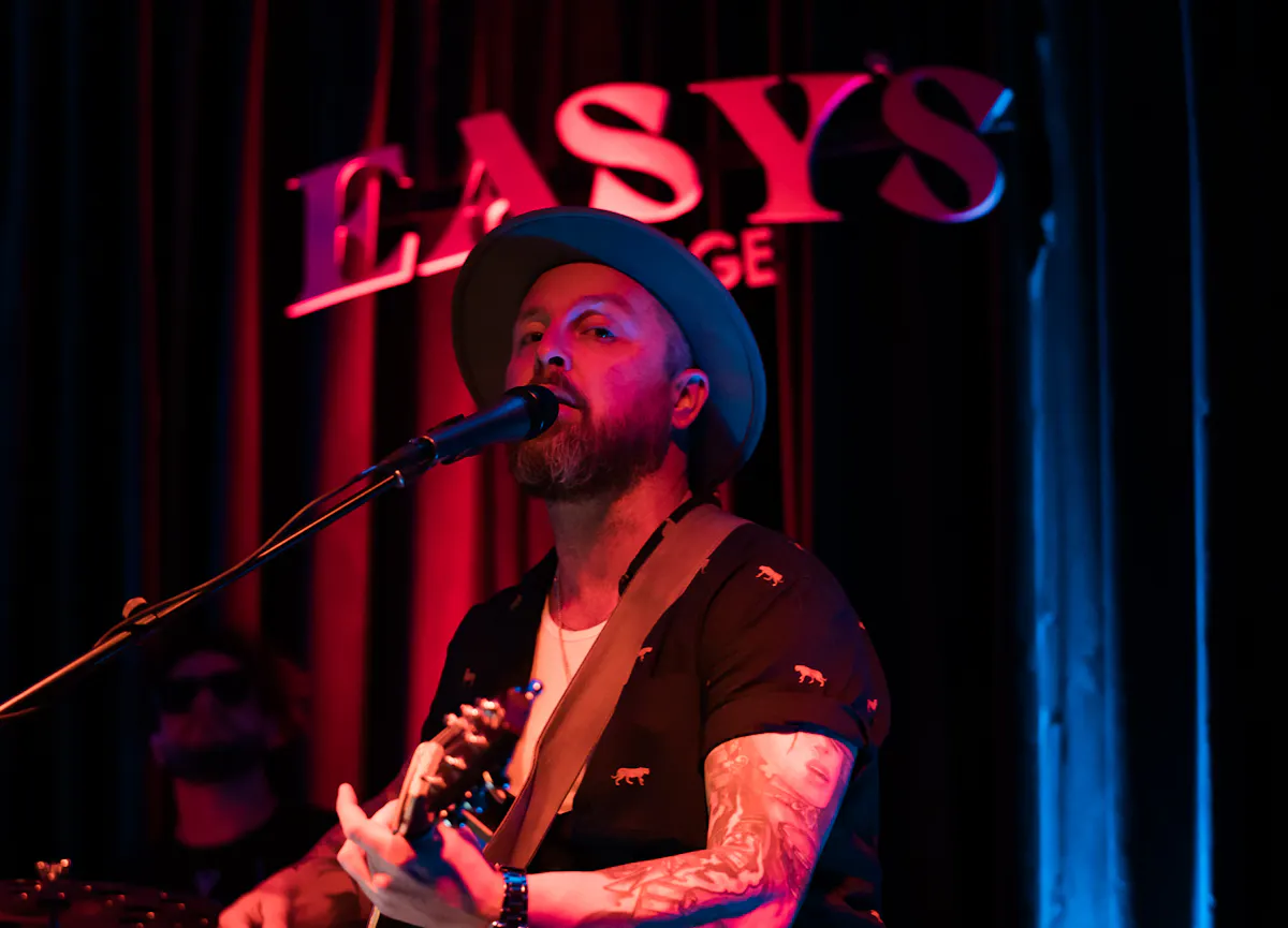 a man playing guitar and singing into a microphone