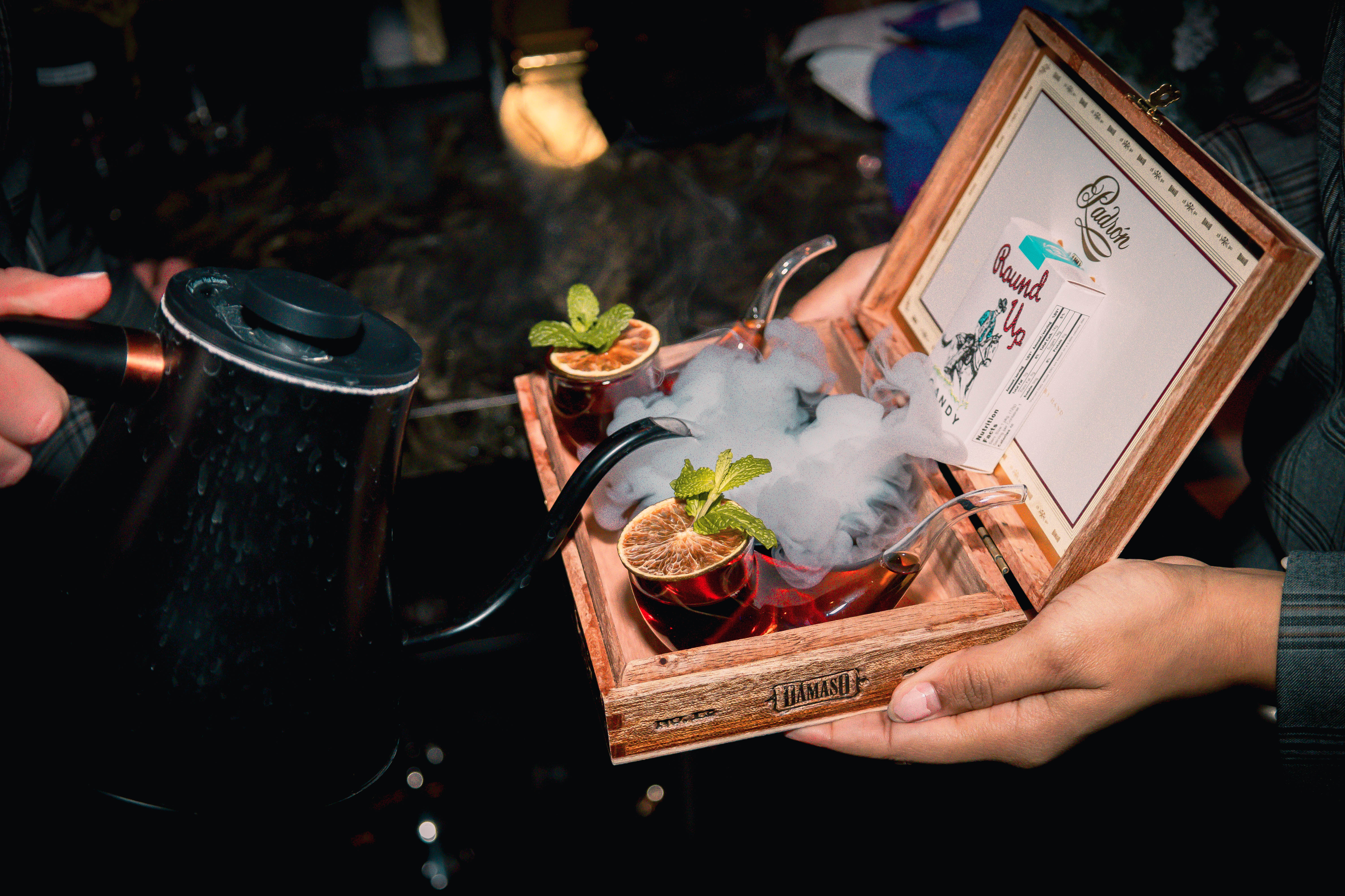 Smoke Show cocktail served in a vintage cigarette case with dry ice smoke, at Easy's cocktail Lounge 