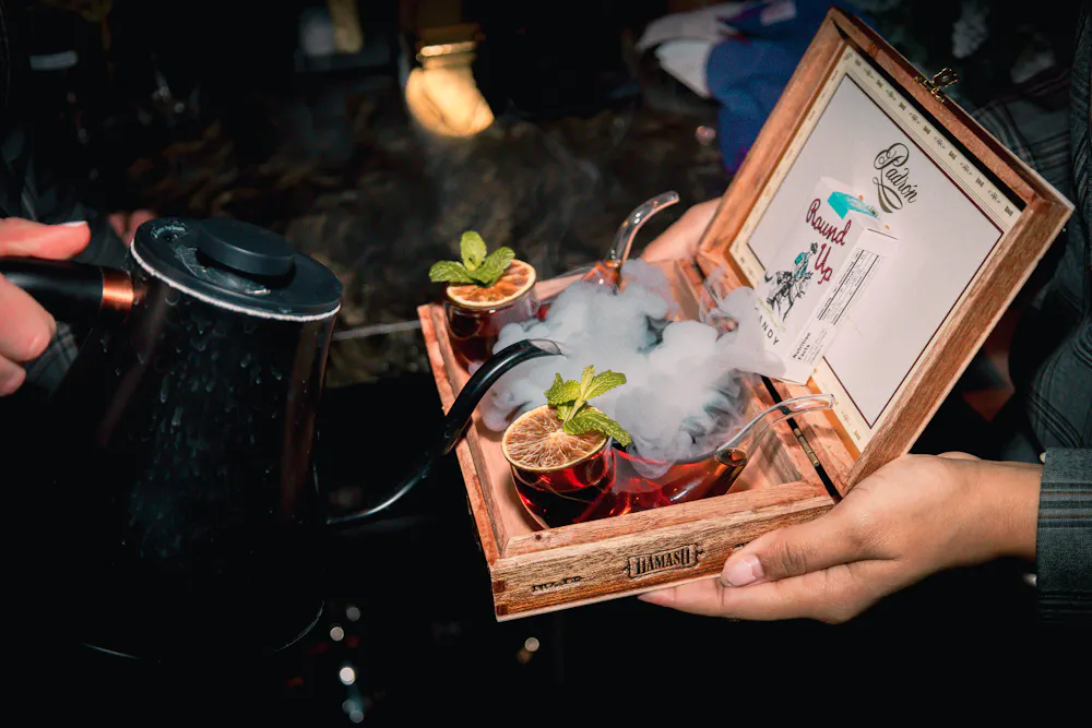 Smoke Show cocktail served in a vintage cigarette case with dry ice smoke, at Easy's cocktail Lounge