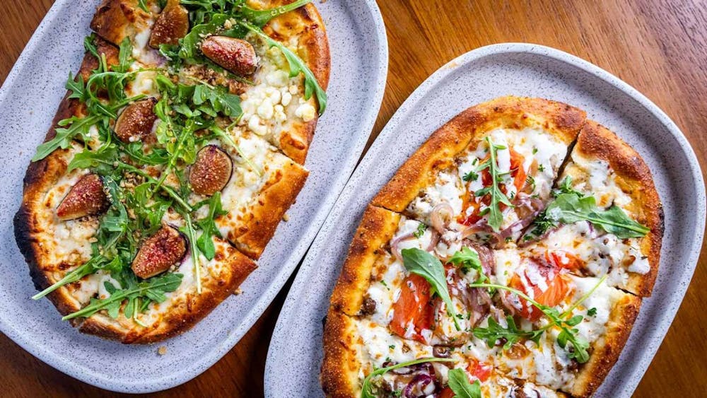 a pizza sitting on top of a wooden table