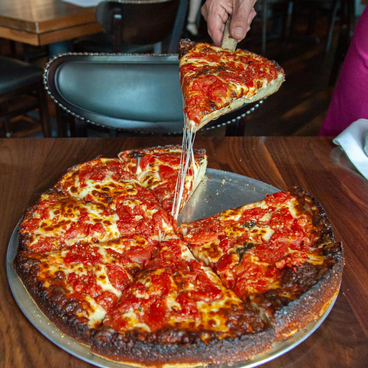 a pizza sitting on top of a pan on a table