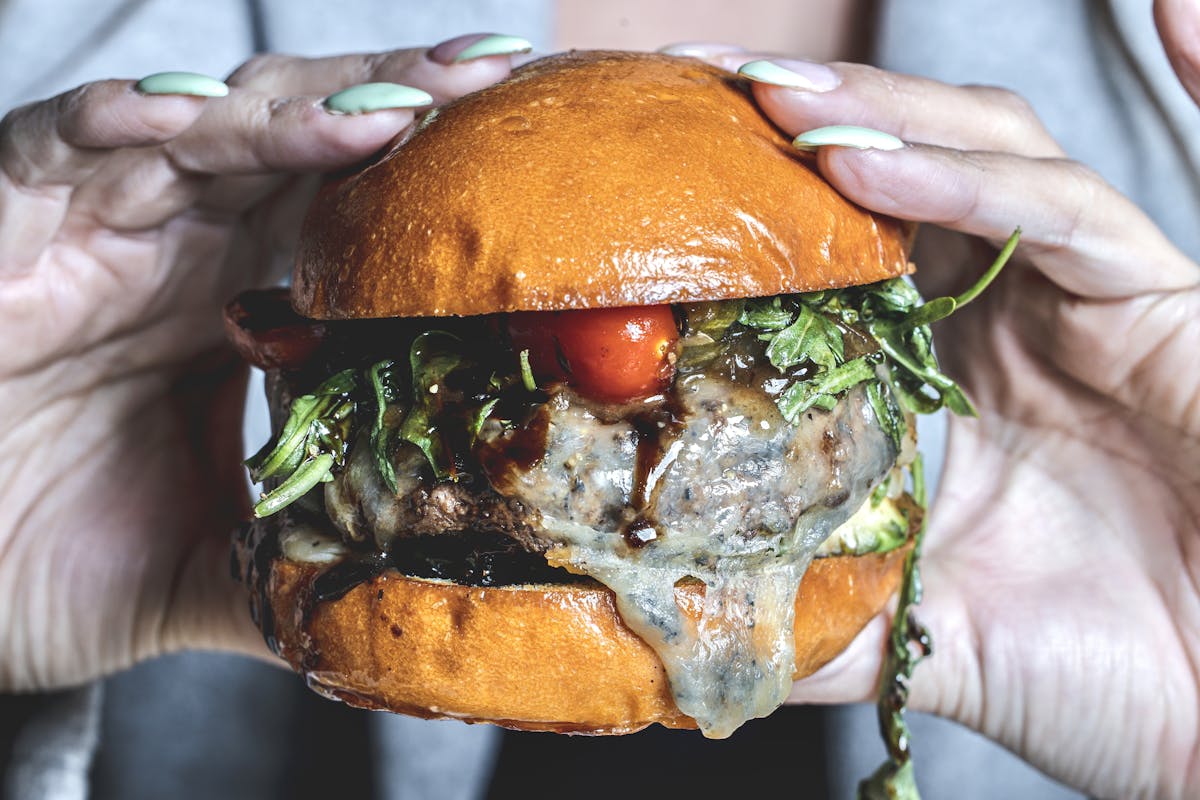 a close up of a person holding a sandwich in his hand
