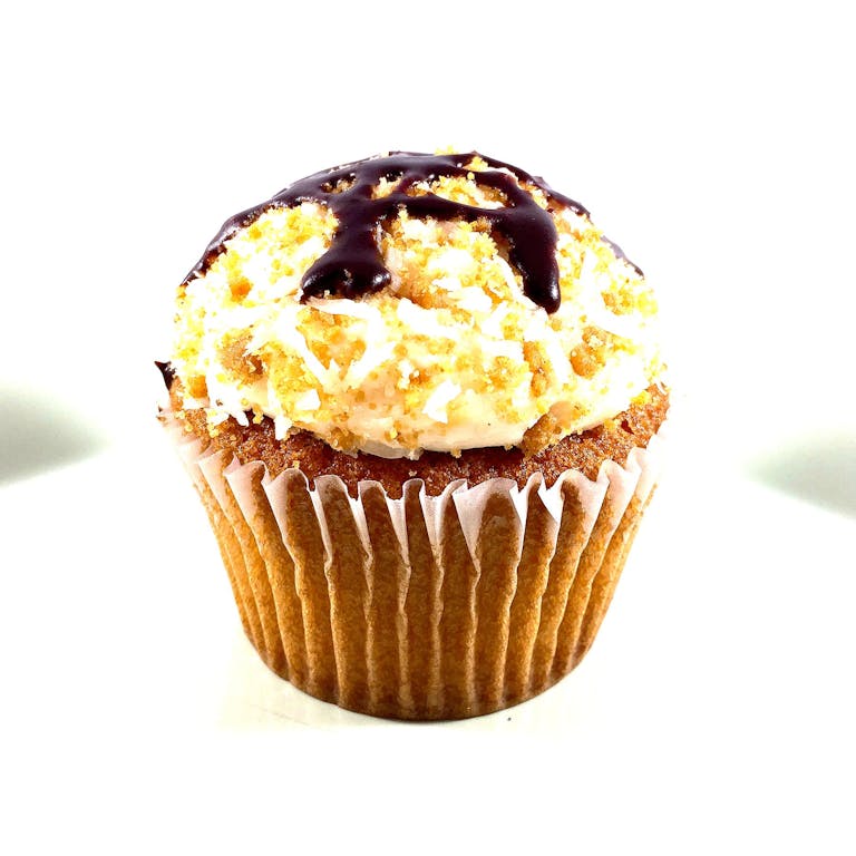 Vanilla cupcakes with a caramel filling, topped with vanilla buttercream dipped in toasted coconut and graham cracker crumble with a drizzle of chocolate sauce.