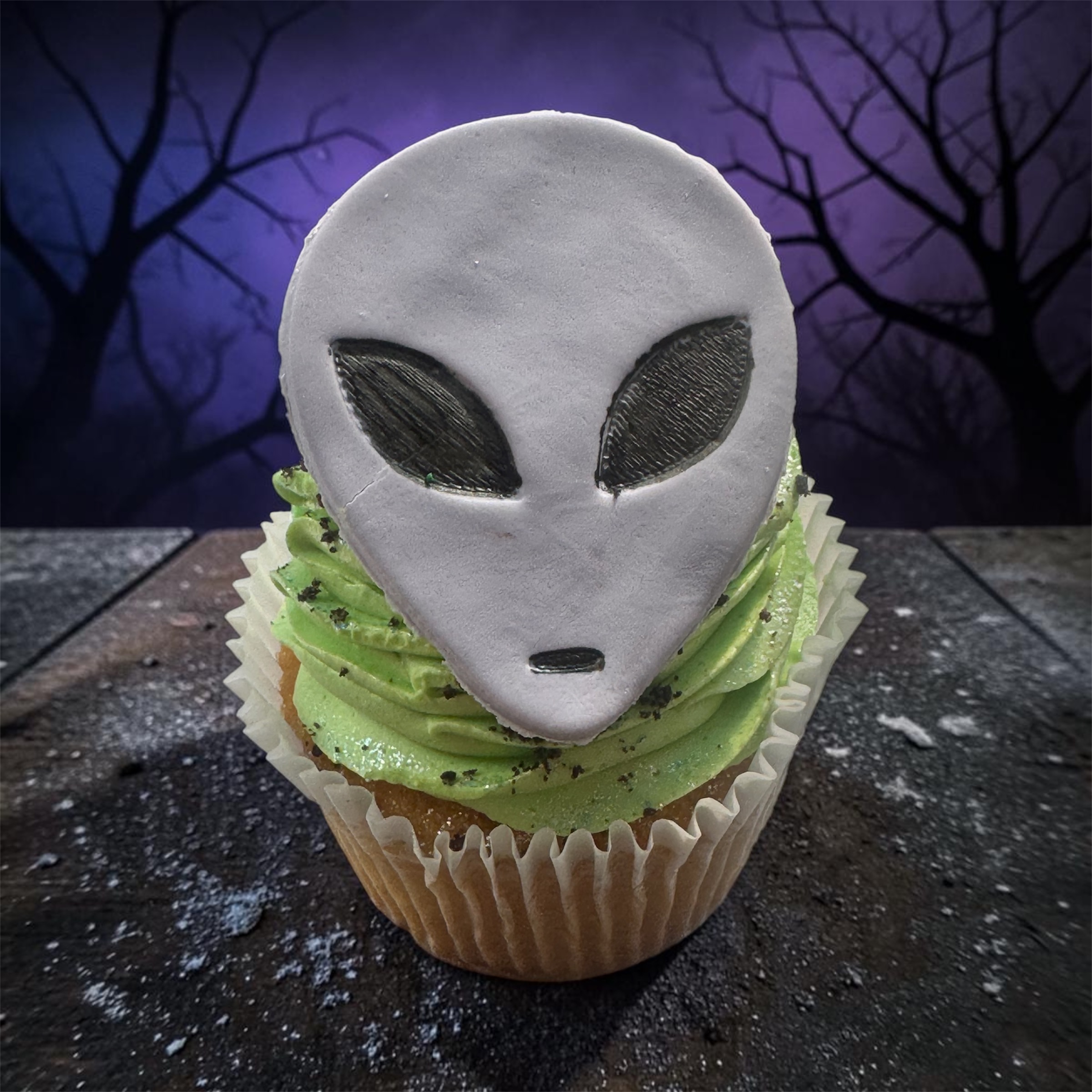 a cupcake with a alien face on top