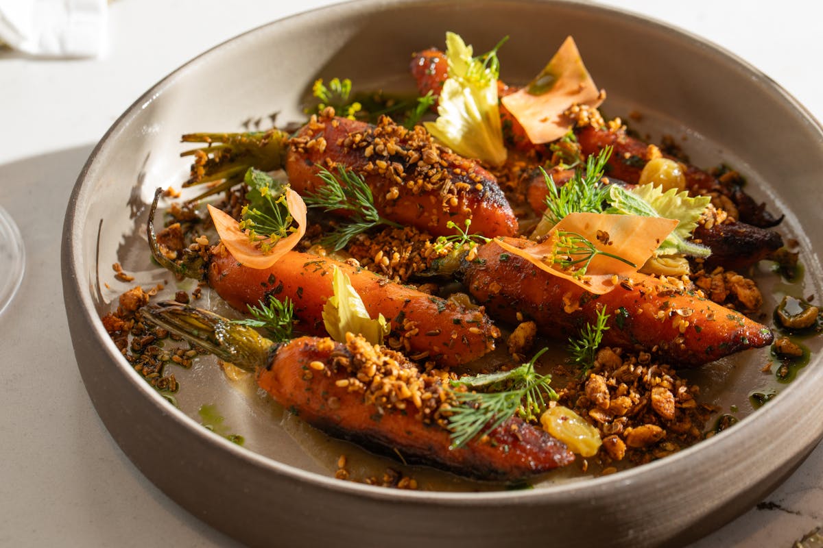 a bowl filled with meat and vegetables on a plate