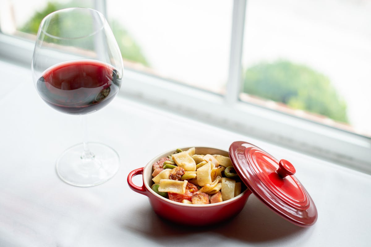 a bowl of food and a glass of wine