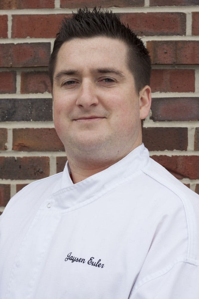 a man standing in front of a brick building