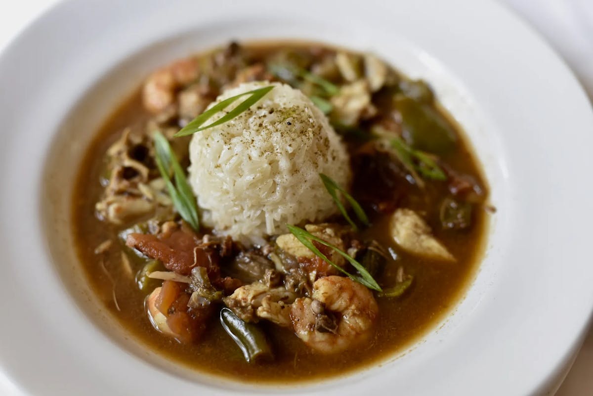 a bowl of soup with meat and vegetables on a plate