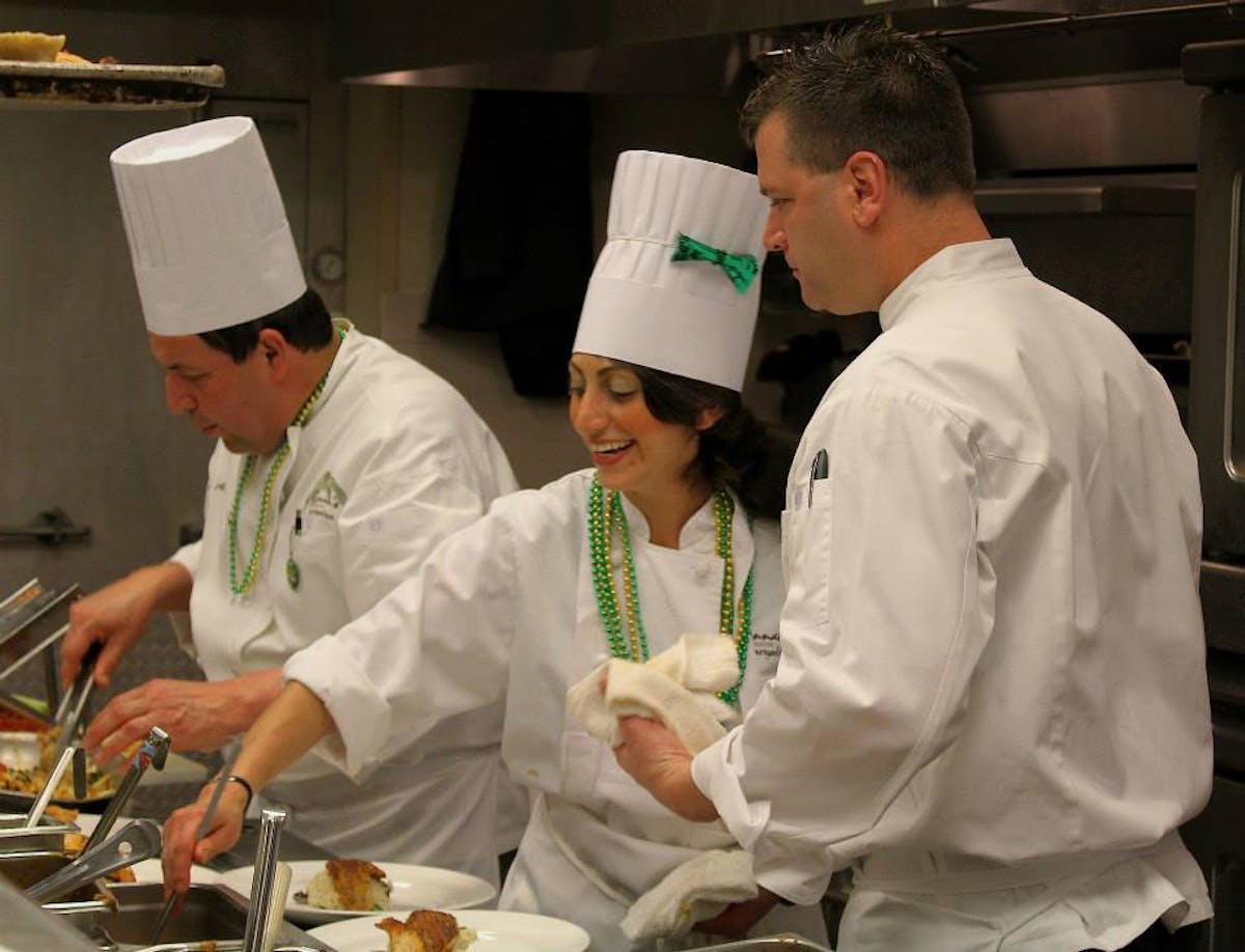 a group of people preparing food in a kitchen