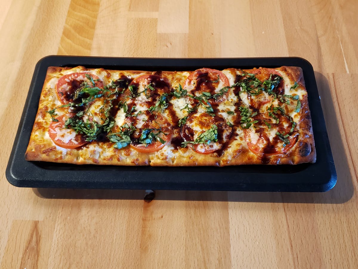a pizza sitting on top of a wooden cutting board