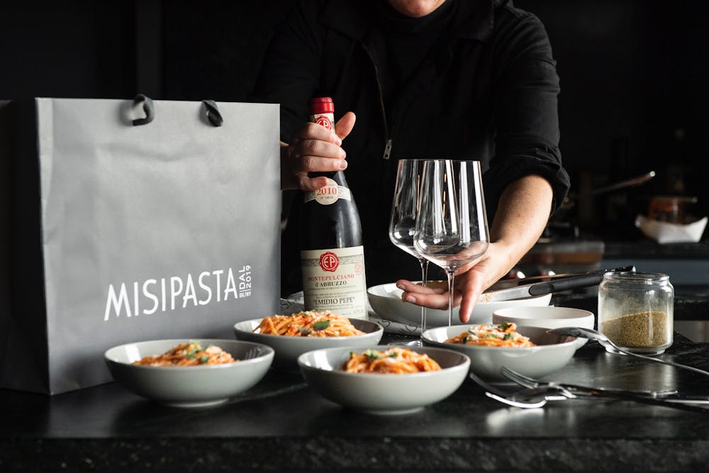 a person sitting at a table with food and drinks