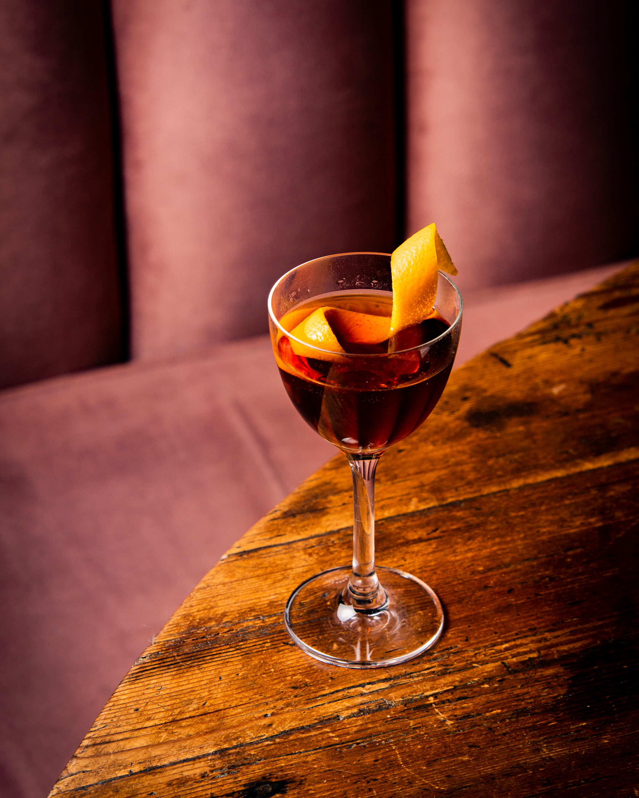 a glass of wine sitting on top of a wooden table