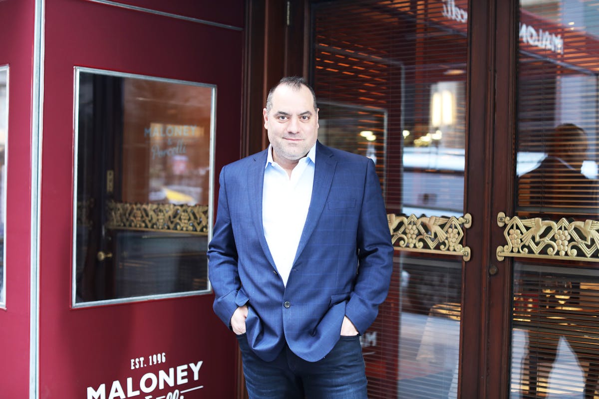 a man in a suit standing in front of a window