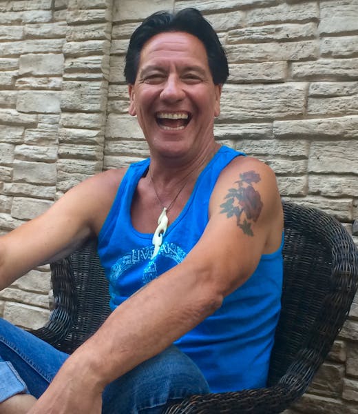 a woman in a blue shirt and smiling at the camera