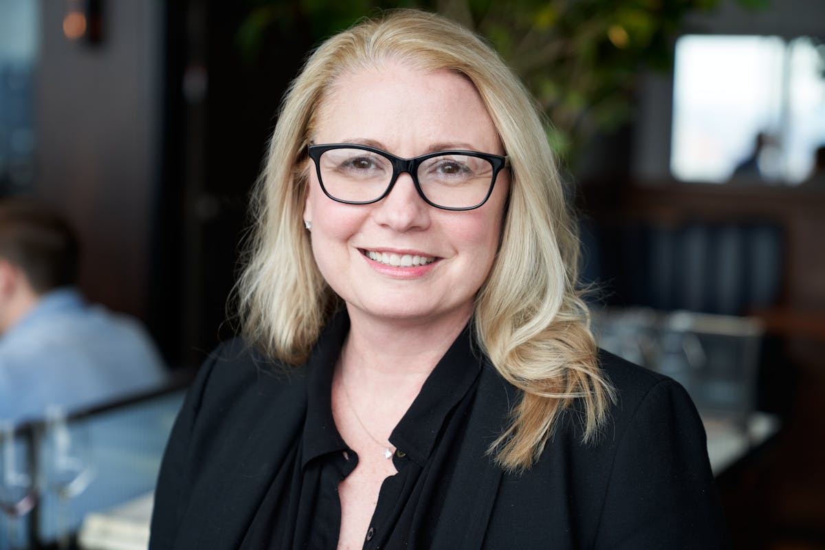 a person wearing glasses and smiling at the camera