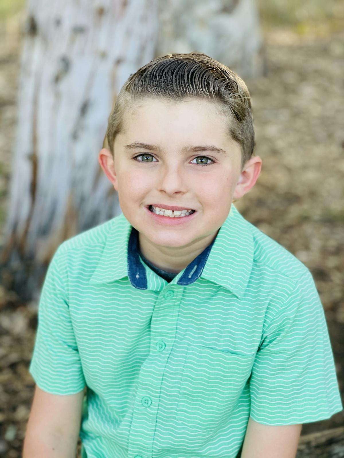 a young boy wearing a green shirt