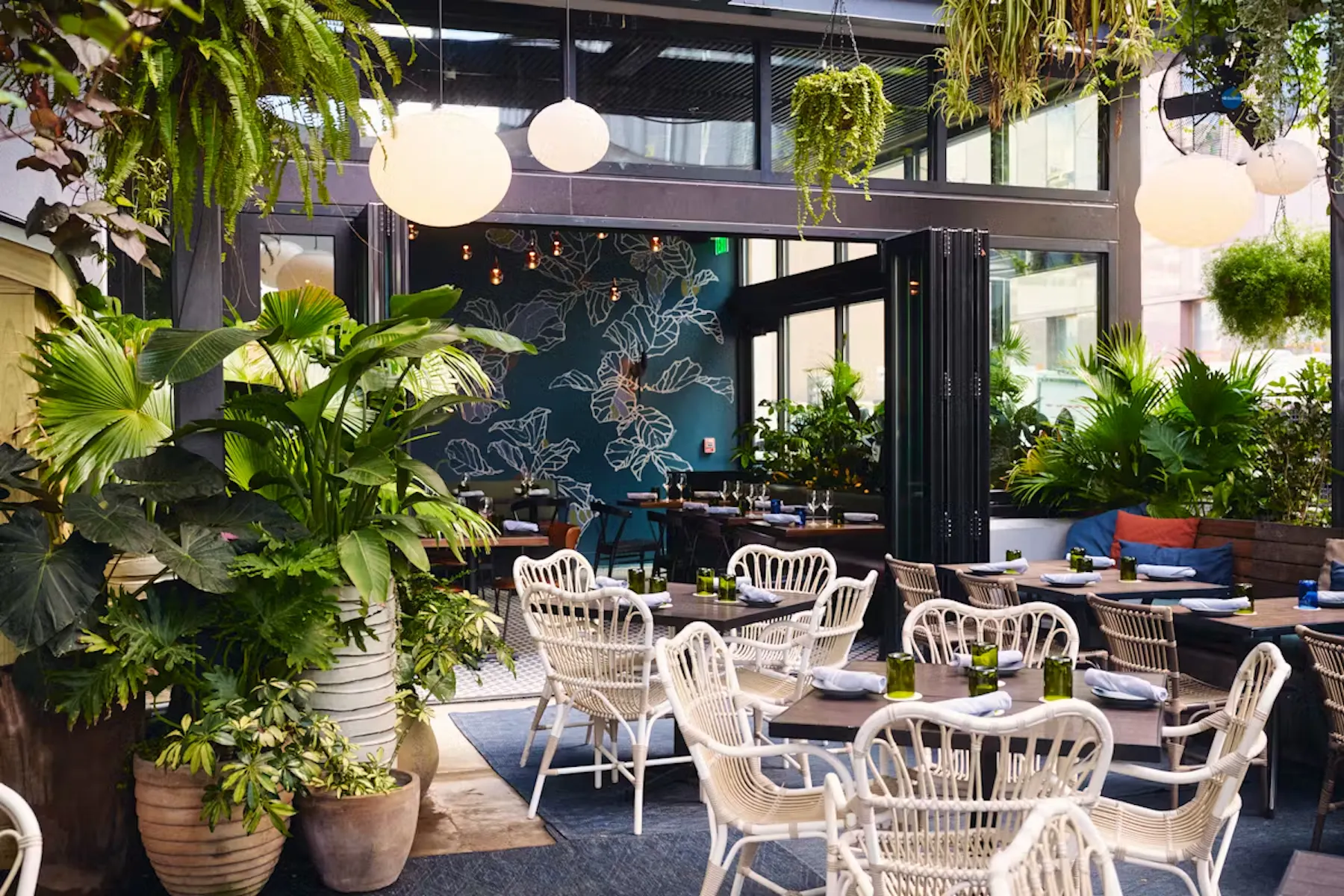 a room with tables and chairs and plants