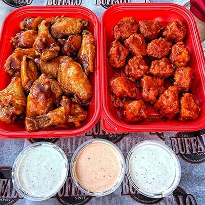 Two plates of chicken wings with a variety of sauces for lunch in Huntington Park CA.