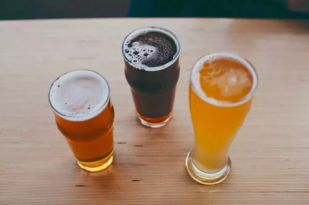 three beers on a wooden table