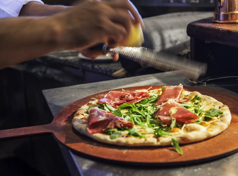 a pizza sitting on top of a wooden cutting board