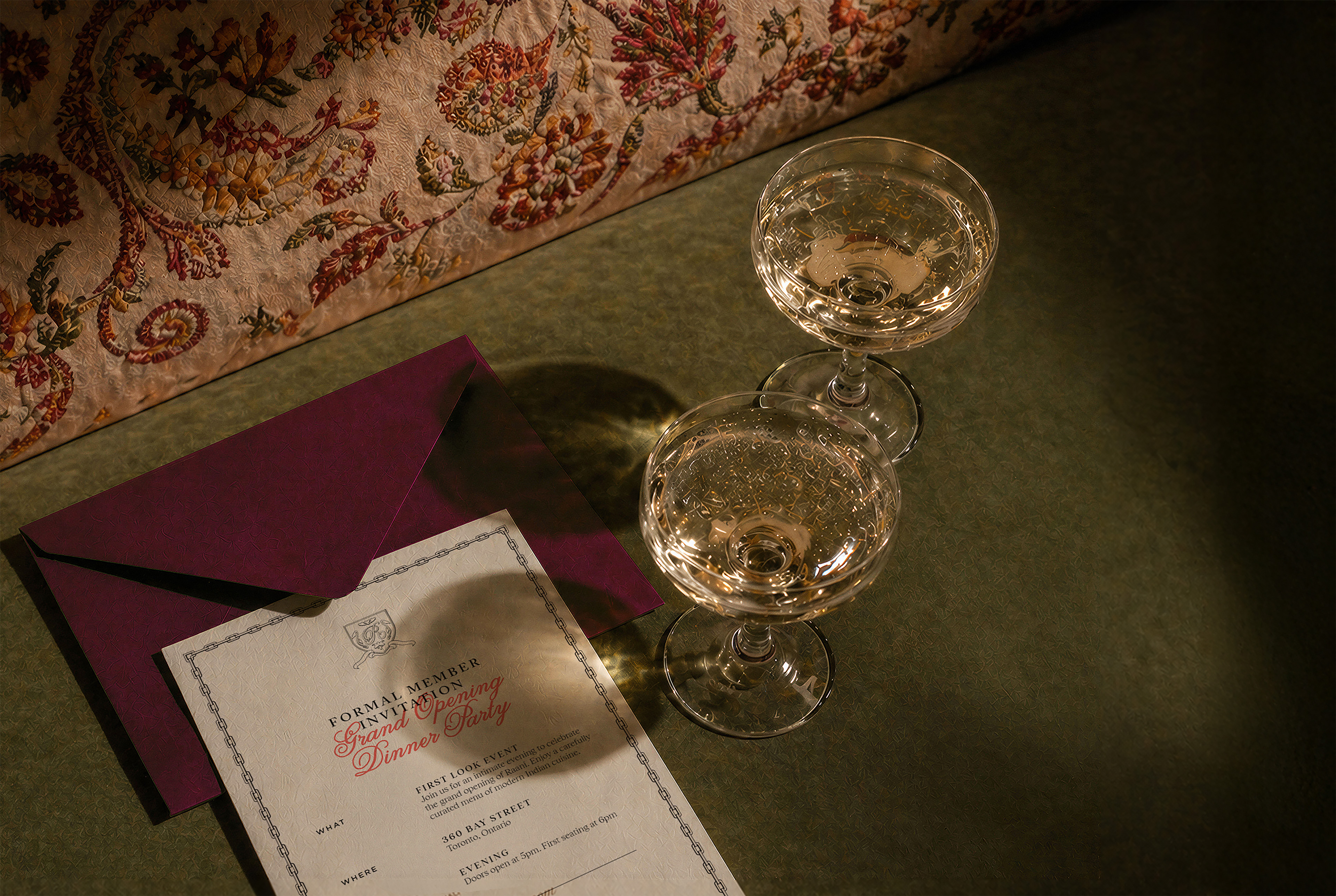 two glasses of champagne next to a envelope