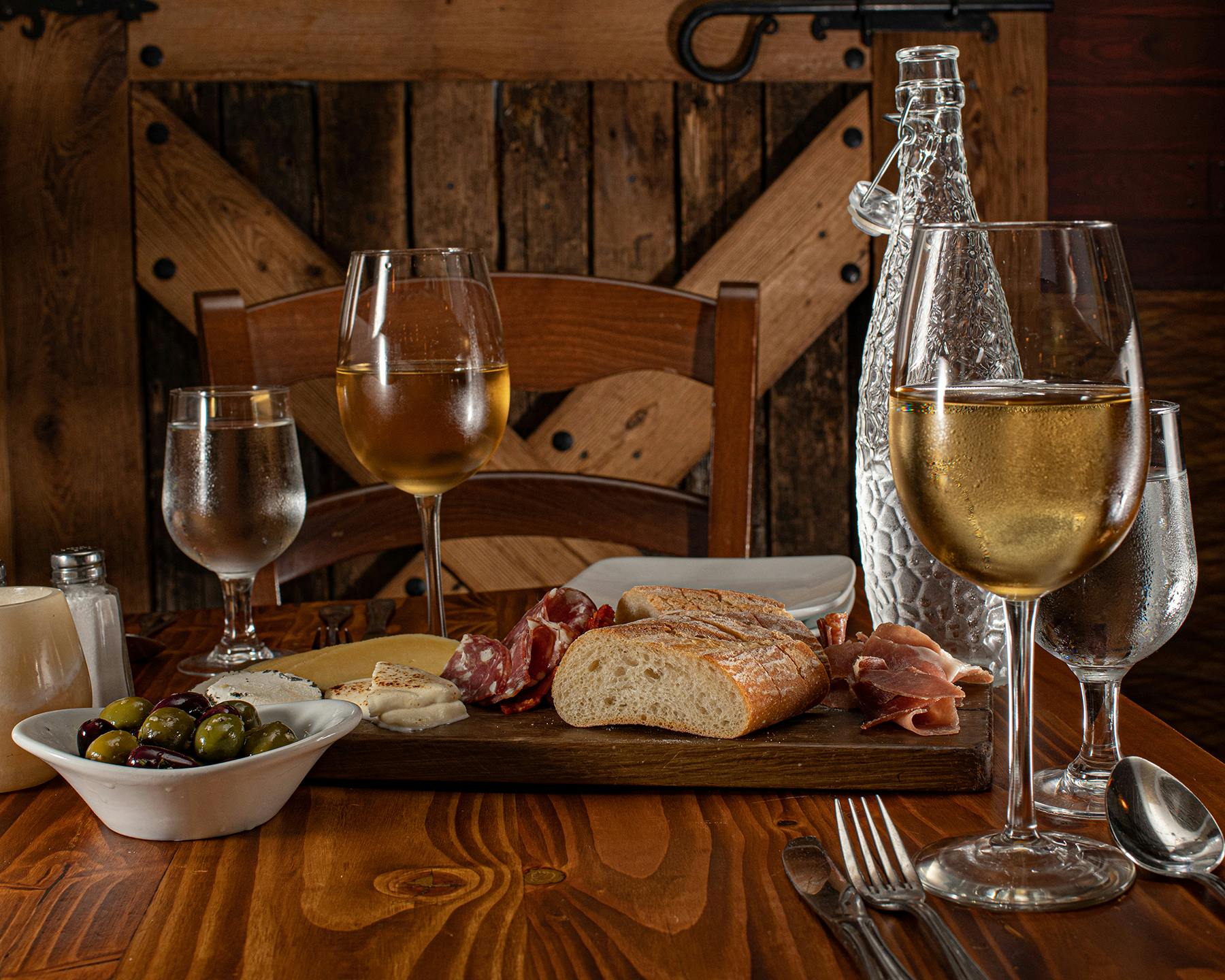 a glass of wine sitting on top of a wooden table