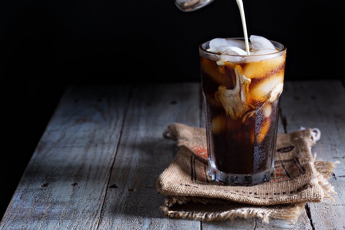 a cup of coffee sitting on top of a wooden table