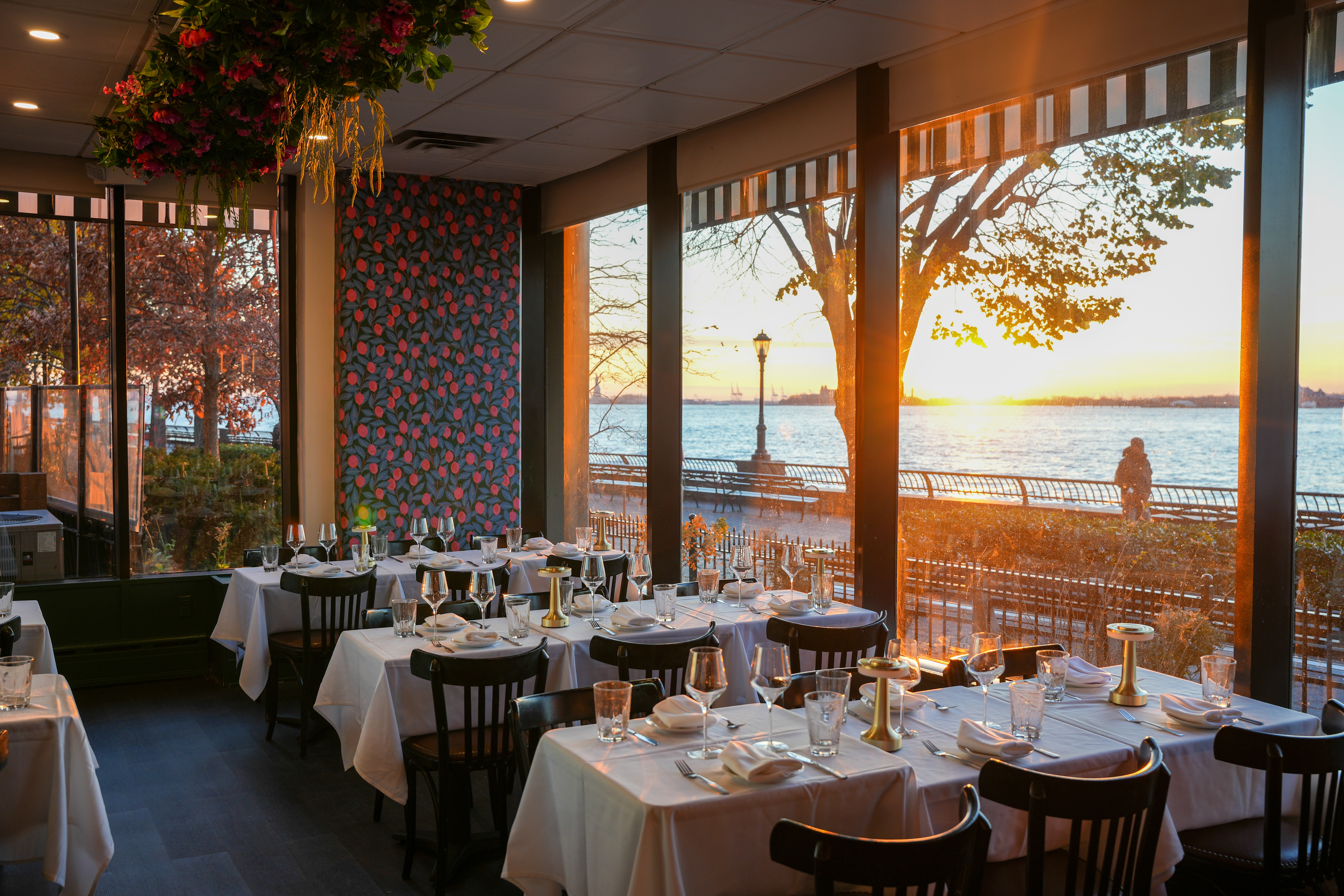 Indoor dining room with floor-to-ceiling windows and Hudson River views