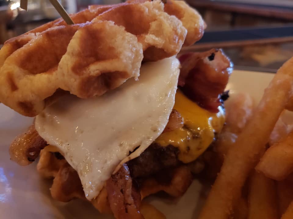 a close up of a sandwich and fries on a plate