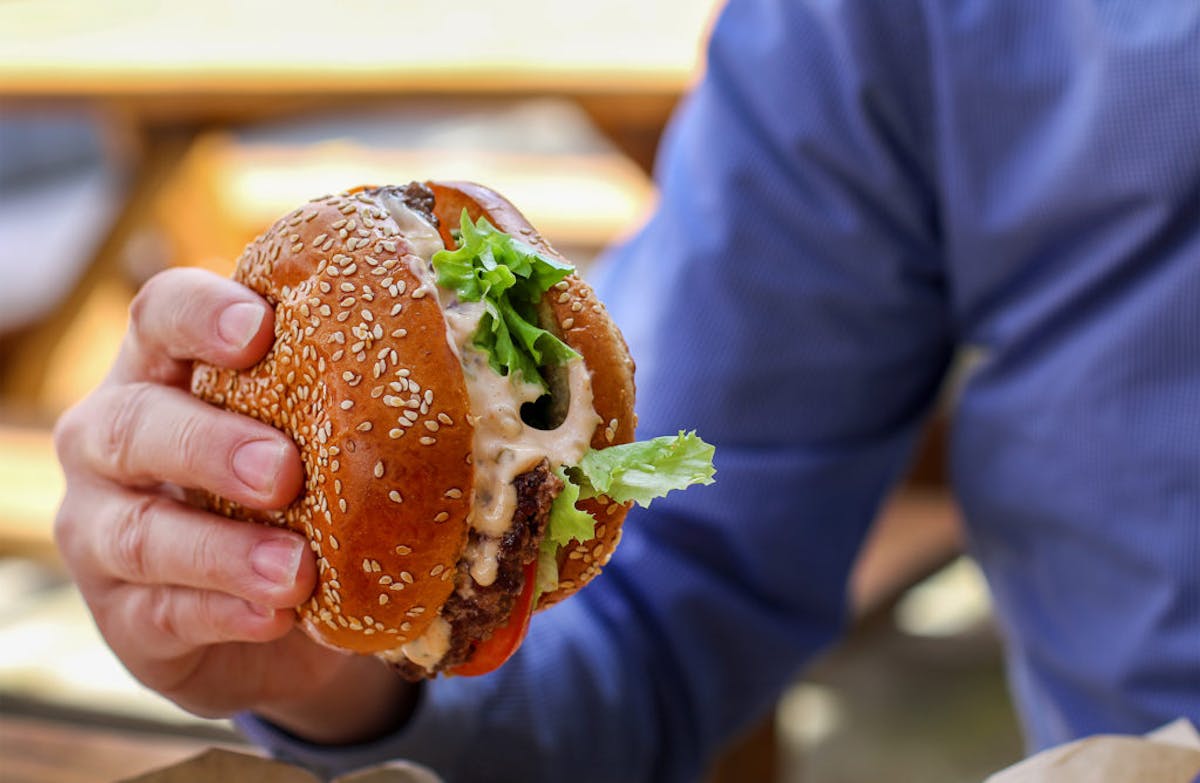 a hand holding a sandwich