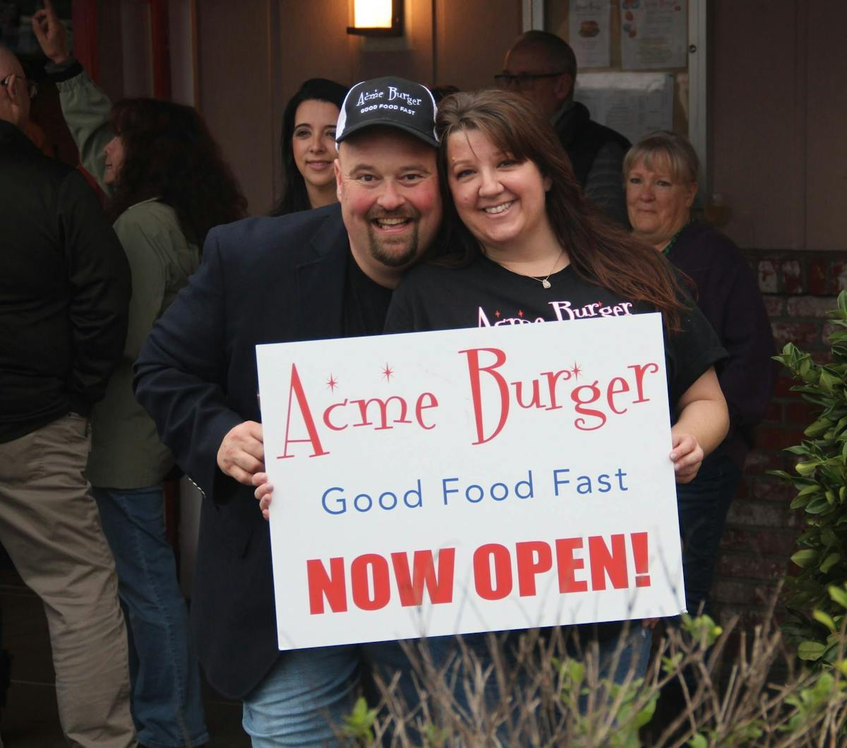 a group of people holding a sign posing for the camera