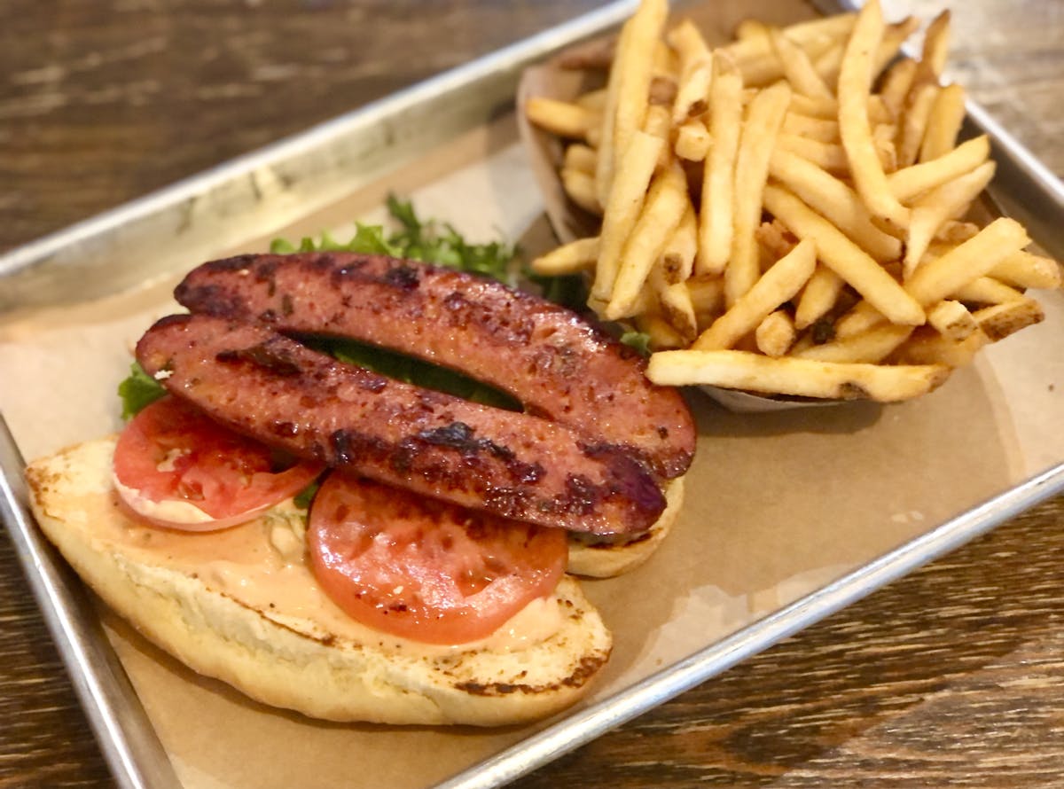 a hot dog sitting on the side of fries