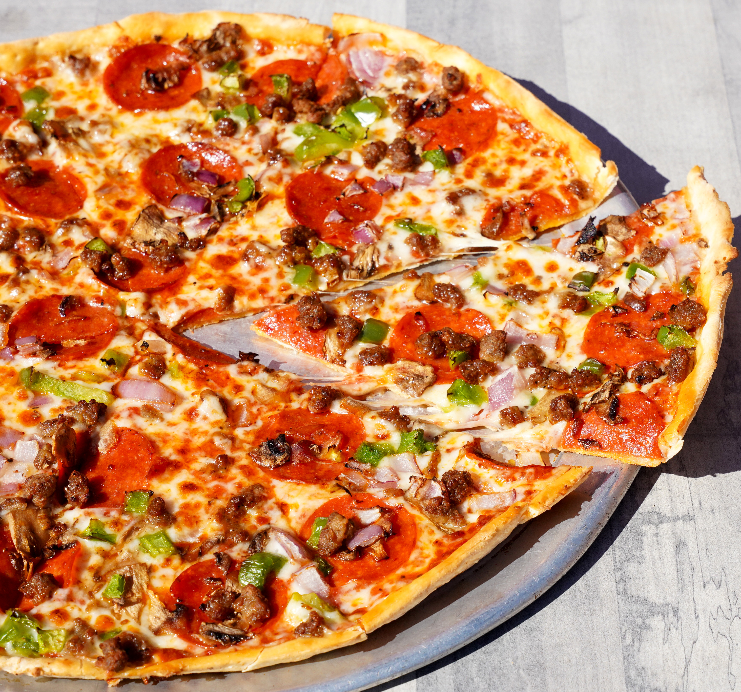 a pizza with meat and vegetables on a plate