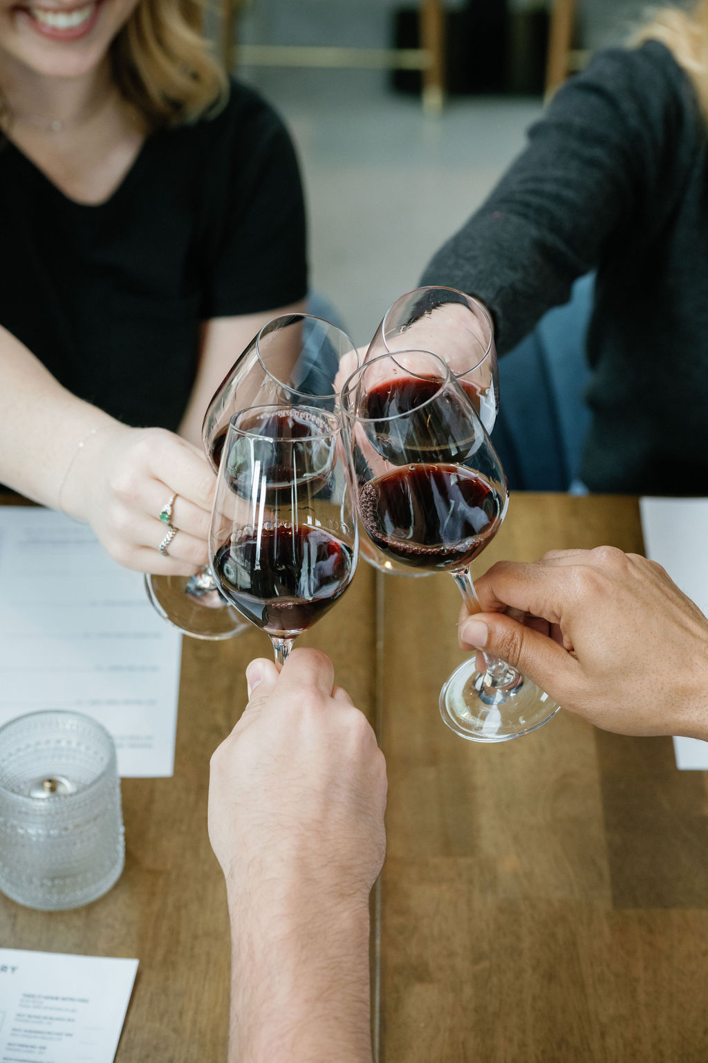 a group of friends clinking four glasses of wine
