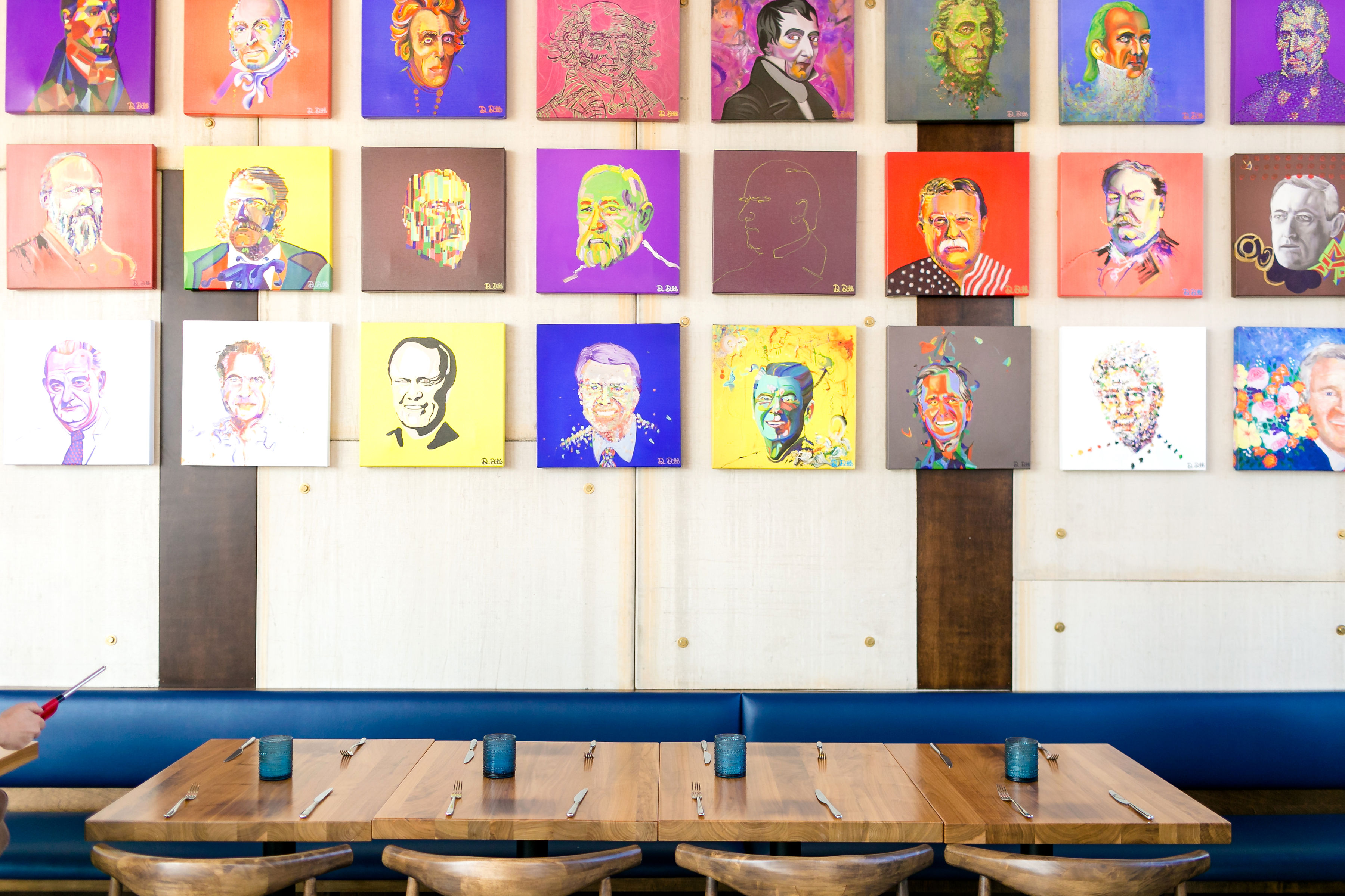 a variety of colorful presidential portraits and a table with blue candles on it