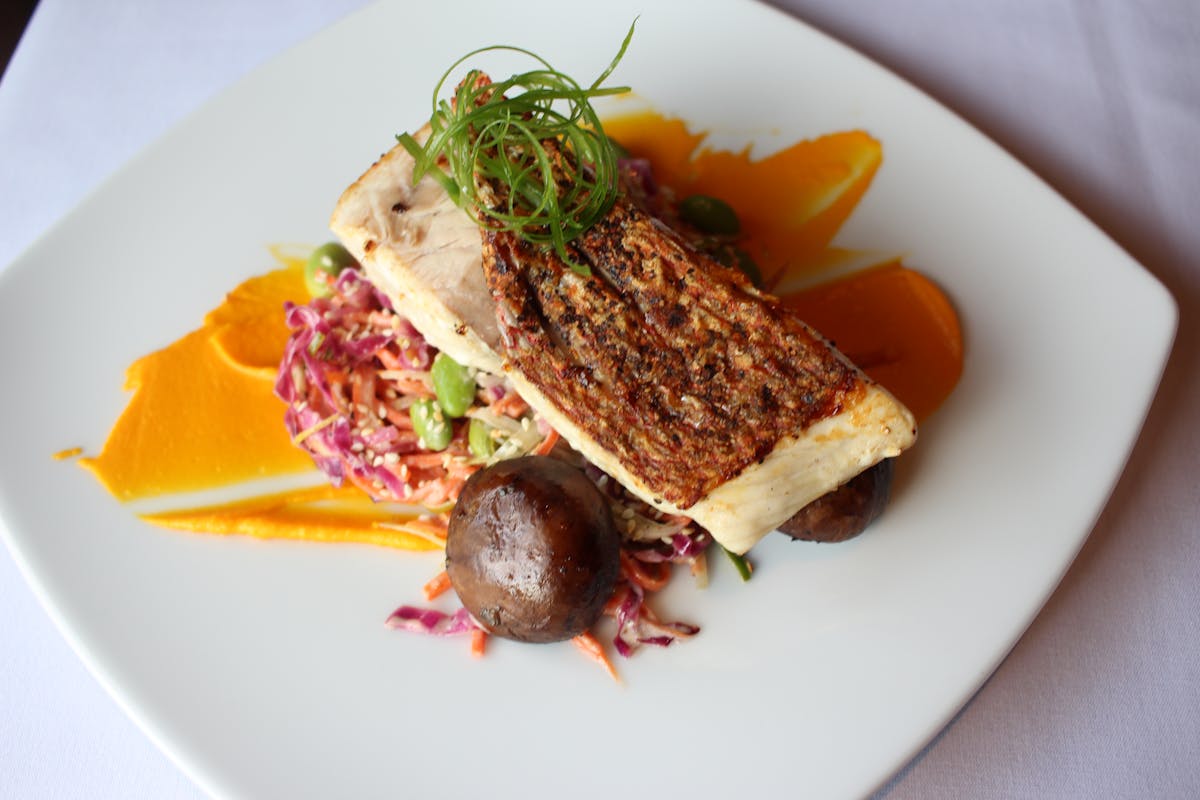 a white plate topped with meat and vegetables