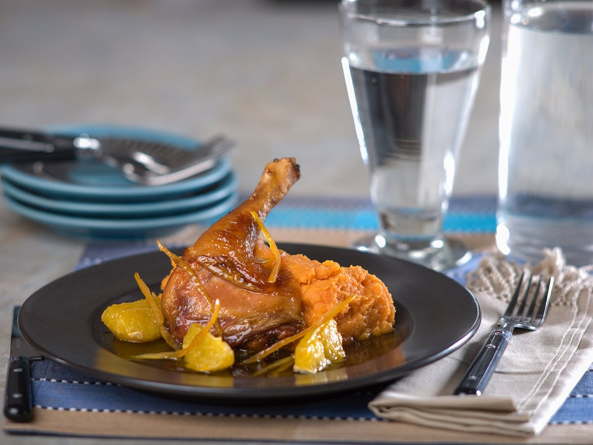 a plate of chicken sided by a glass of water
