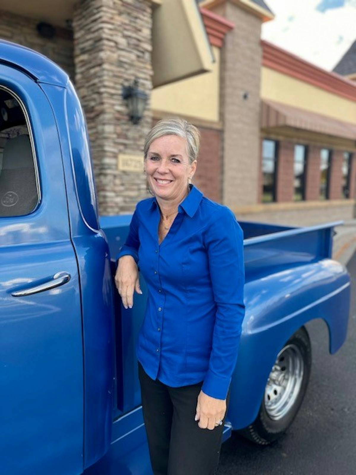 a person standing in front of a blue car